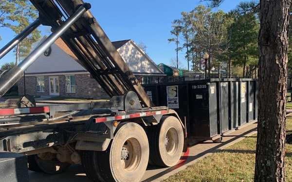 truck unloading metal dumpster