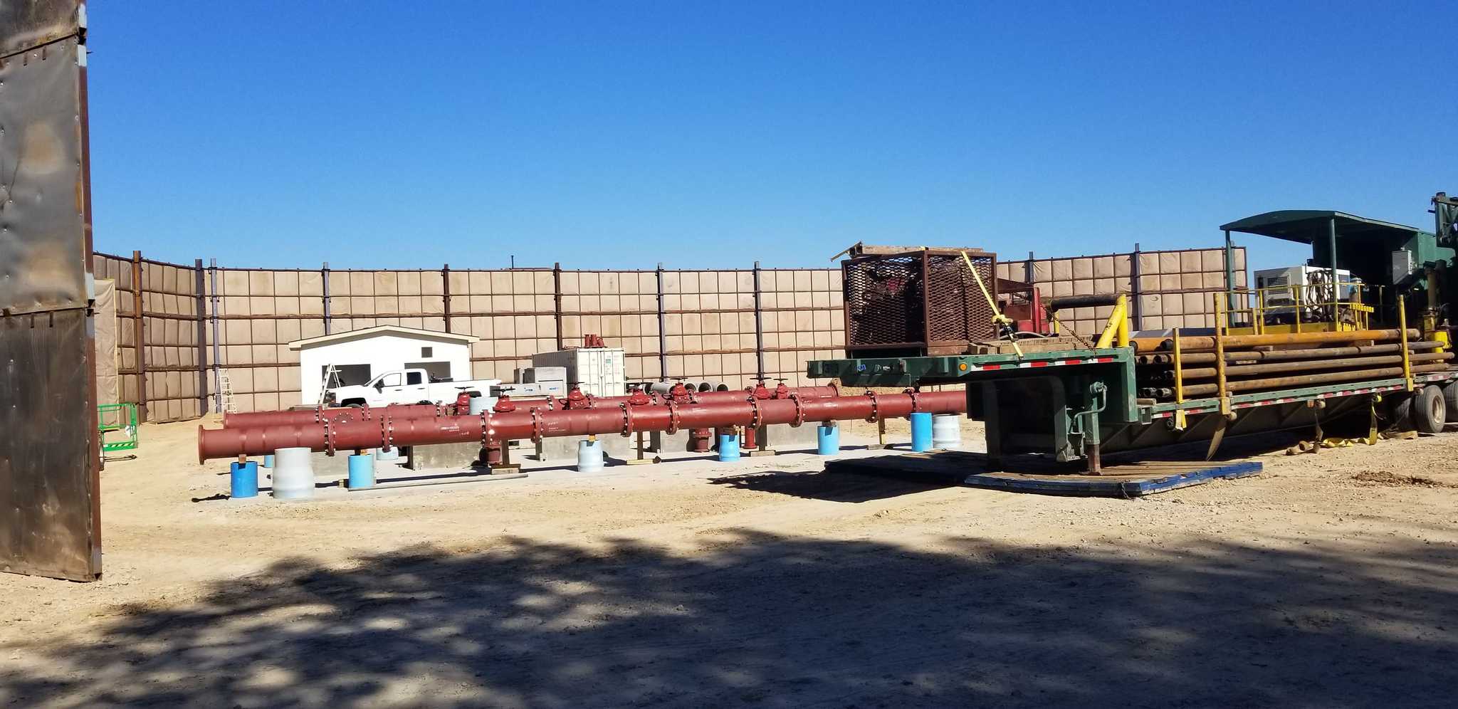 Red pipes and a trailer full of construction supplies